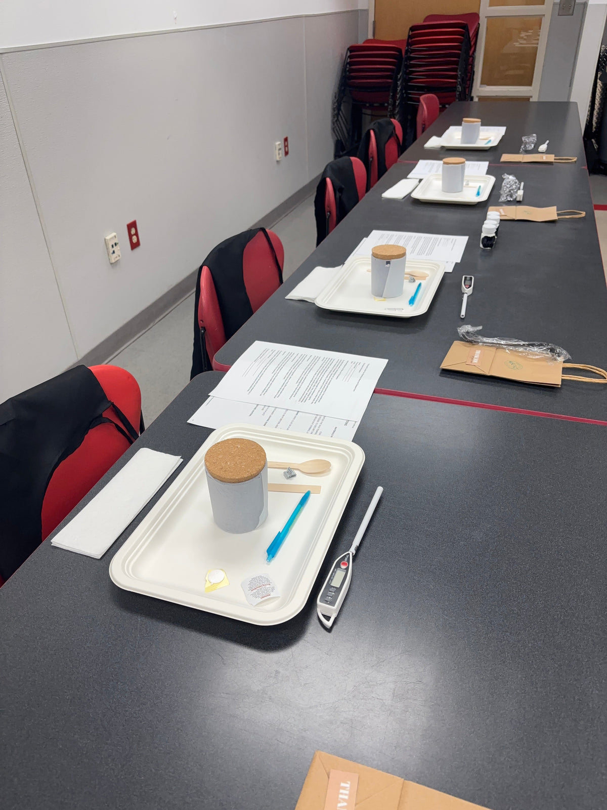 Candle Pour Class setup: trays with cork-lidded candle jars and tools for designing and pouring candles.